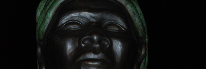 An image of Alison Saar's "Swing Low: Harriet Tubman Memorial" in Harlem at night | Jon Mannion/Flickr (CC BY-NC-ND 2.0)