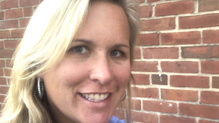 Laura Lewis Brown wears her blonde hair down and smiles at the camera