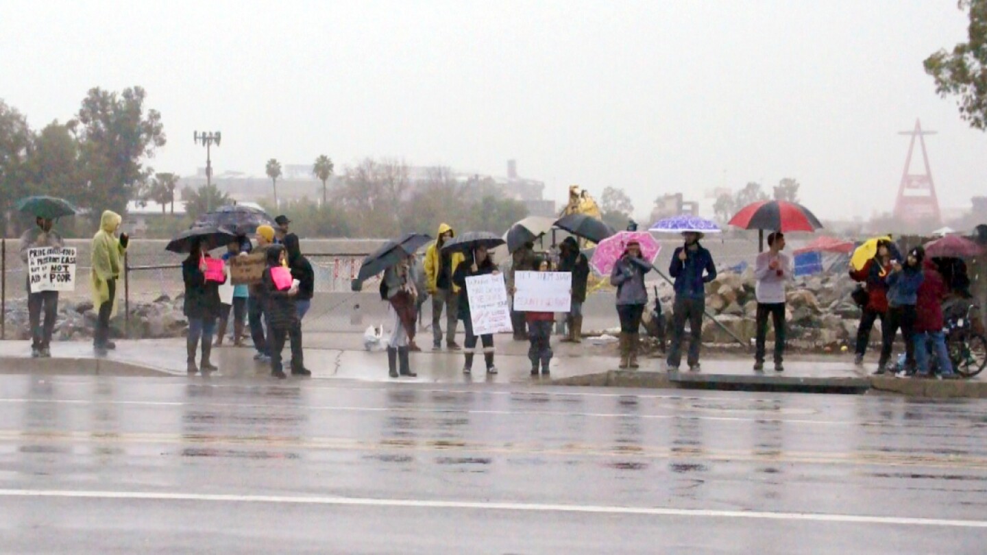 Demonstrators hold signs along Chapman Ave. next to the Santa Ana River | photo by Nick Gerda/Voice of OC