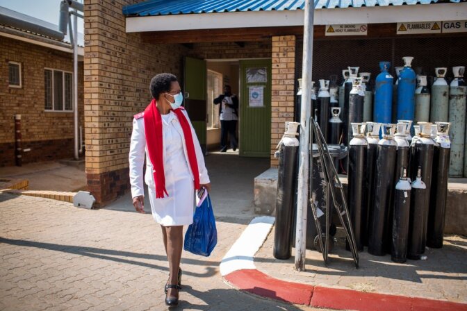 Kedibone Mdolo, projects coordinator of the Democratic Nursing Organisation of South Africa (DENOSA) looks back at empty oxygen tanks waiting to be collected at the Taung Hospital in Taung, North West Province, South Africa, on Sept. 3, 2020. | TRF
