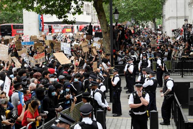 People holding banners in front of police officers near Downing Street during a "Black Lives Matter" protest following the death of George Floyd who died in police custody in Minneapolis, London, Britain, June 3, 2020. | REUTERS/Toby Melville