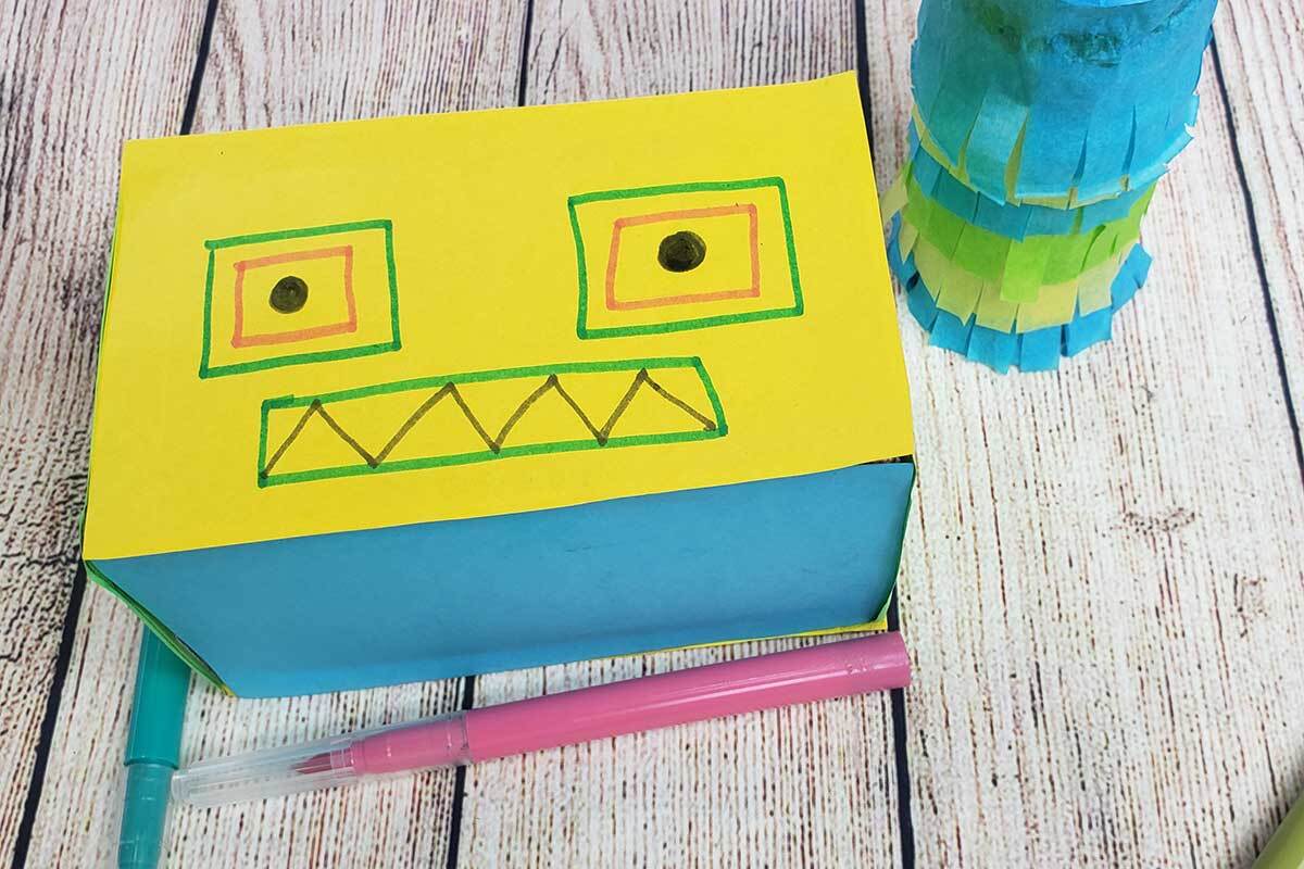 La cabeza de un robot de cartón y papel de construcción.