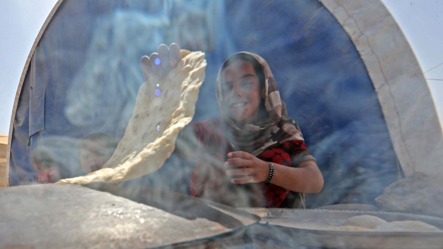 A displaced Iraqi girl bakes bread at the Hammam al-Alil camp for internally displaced people south of Mosul on May 26, 2017. | Karim Sahib/AFP/Getty Images