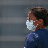 A medical technician wears a face mask at a drive-thru testing site for COVID-19.