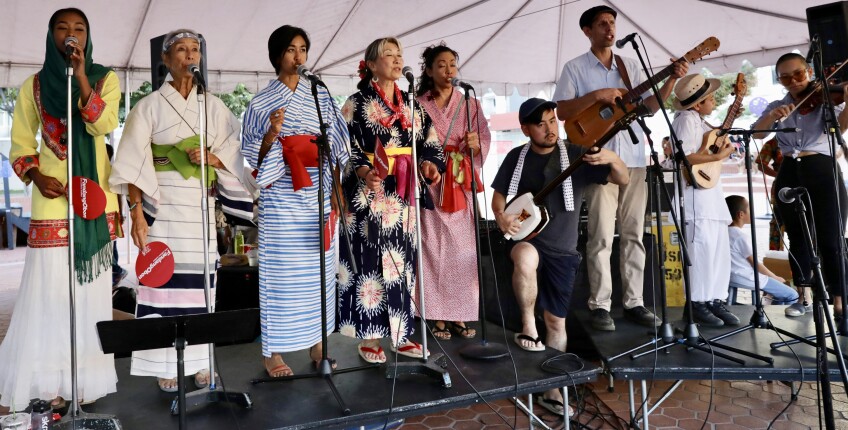 FandangObon Festival musicians wear traditional robes while singing on stage.