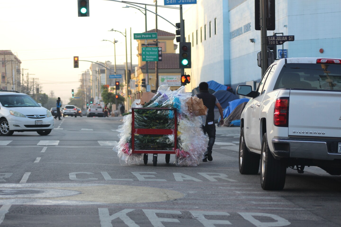 Man with flowers on cart pulls them through San Julian Intersection | Karen Foshay