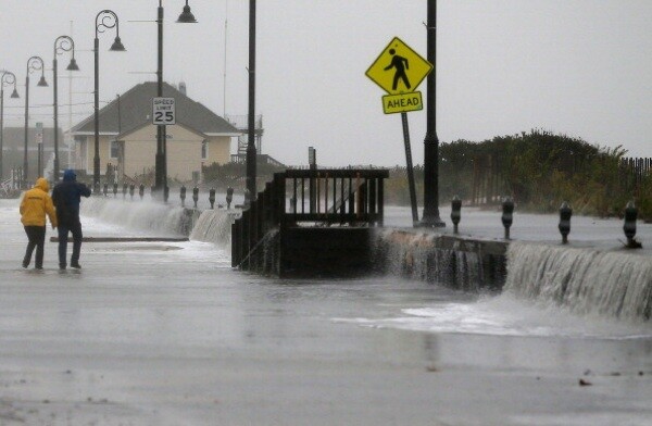 People walk across Beach Ave. as flood waters from Hurricane Sandy rush in on October 29 in Cape May, New Jersey. | Photo by Mark Wilson/Getty Images)