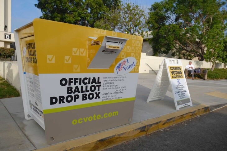 Drive-through ballot drop-off boxes and COVID-19 safety signs outside the Orange Country Registrar. | Chava Sanchez/LAist