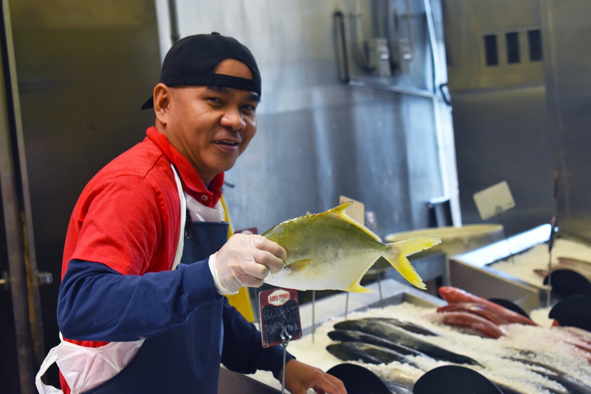 A butcher poses with a piece of freshly caught and delivered fish. | Jacqueline Lee