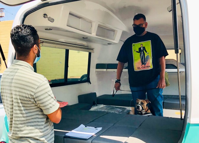 Pichardo stands inside the Mobile Art Lab, a teal and white trailer.