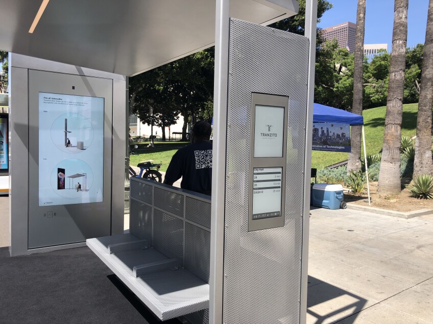 A prototype bus shelter shows digital displays in multiple placements. 