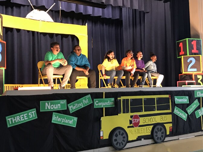 Students sit on stage in answering questions from the audience of McKinley K-8 School of Integrated Arts.