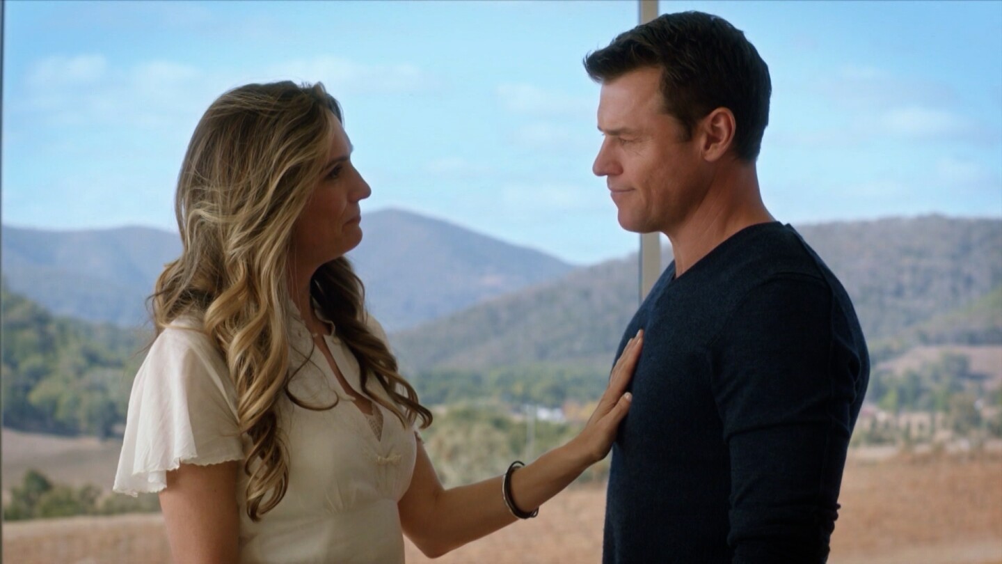 A man and woman look at each other, with the woman placing a hand on the man's chest. | From "The Heart Guy: S3 E3"