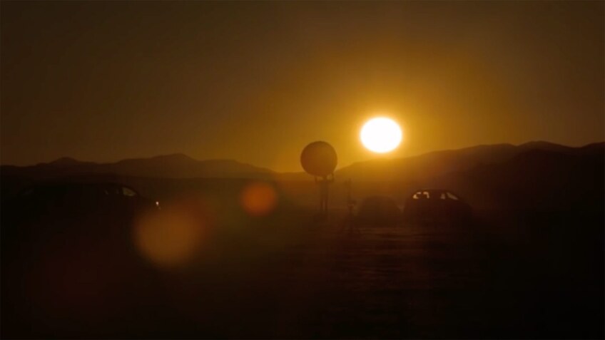 A person holds a large ball close to the sun