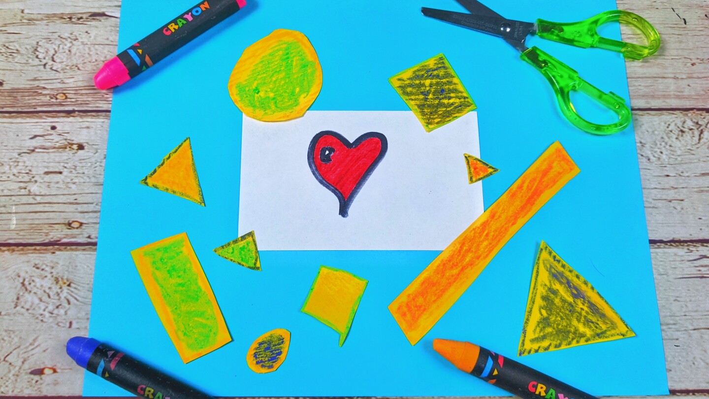 A sheet of blue paper with colorful cut outs of different shapes on it surrounded by crayons and a pair of green scissors.