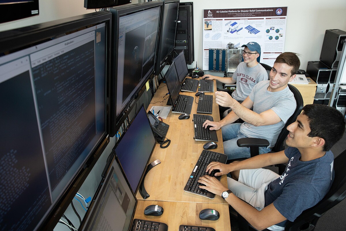 Undergraduates Omar Garcia and Zach Cameron with Grant Mishler in the mission control room at the Robotic Systems Laboratory. R.Mike Rasay