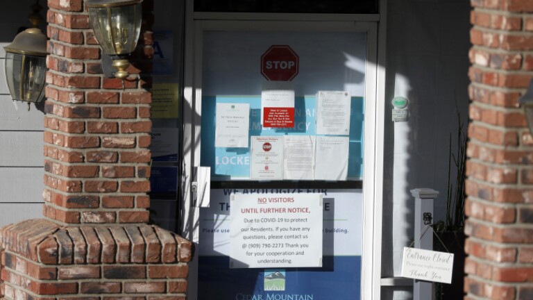 Warning notices are posted on a door at the Cedar Mountain Post Acute nursing facility in Yucaipa, after a COVID-19 outbreak there. | Chris Carlson/AP