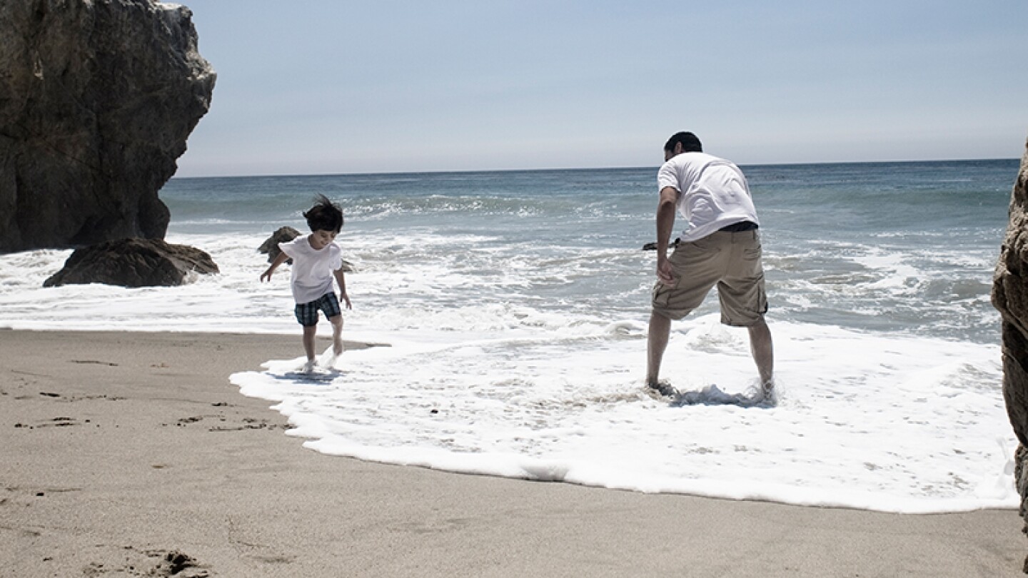 Latino family members play on the beach at Malibu | Photo: depphoto/iStockPhoto