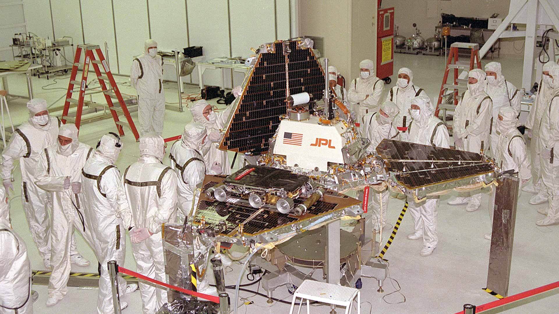 October 1996, Jet Propulsion Laboratory workers are closing up the metal "petals" of the Mars Pathfinder lander. The Sojourner small rover is visible on one of the three petals. | NASA/Flickr