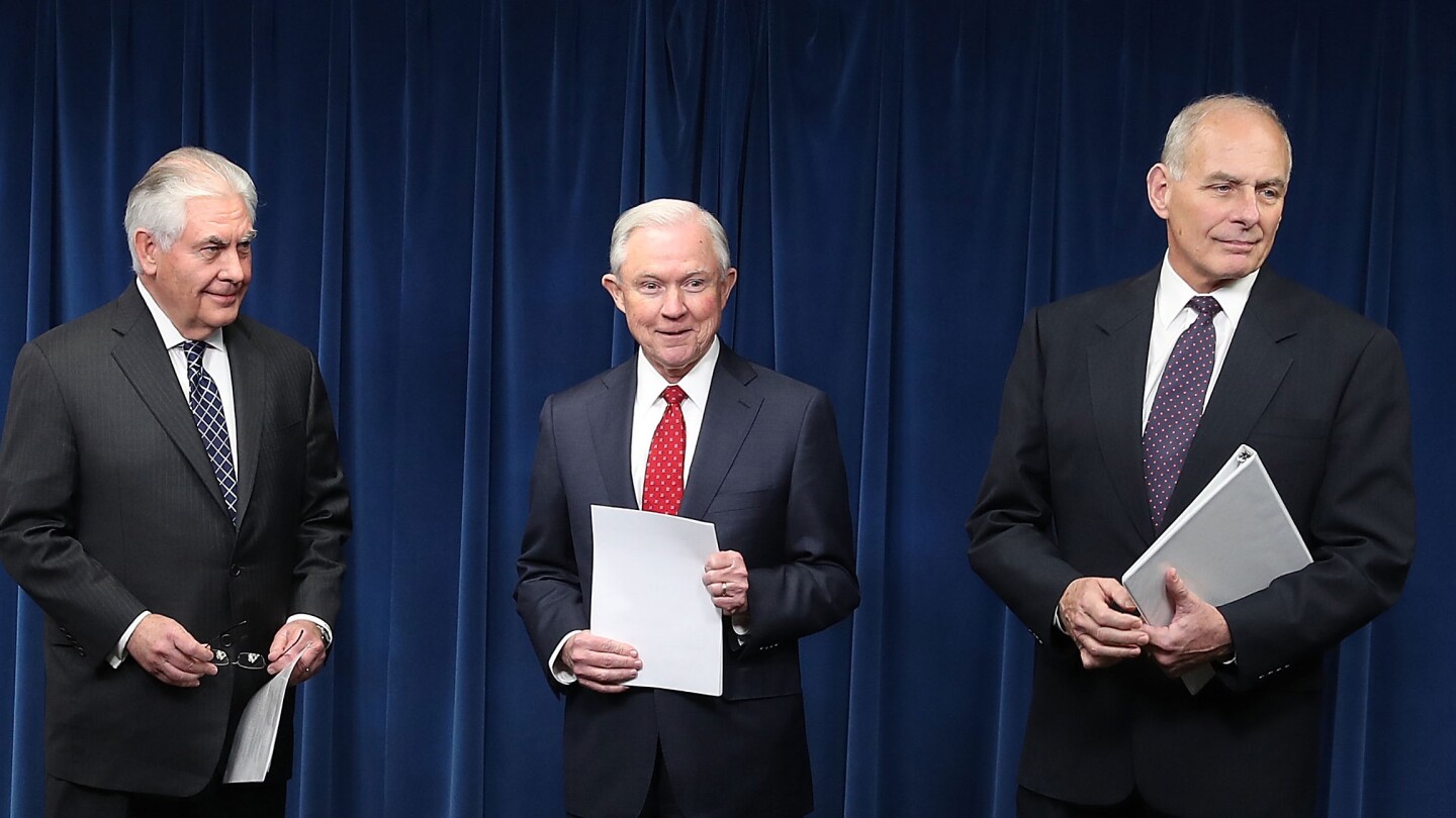 Secretary of Homeland Security John Kelly (R), Secretary of State Rex Tillerson (L) and Attorney General Jeff Sessions prepare to give remarks on a revised travel ban at the U.S. Customs and Borders Protection headquarters.