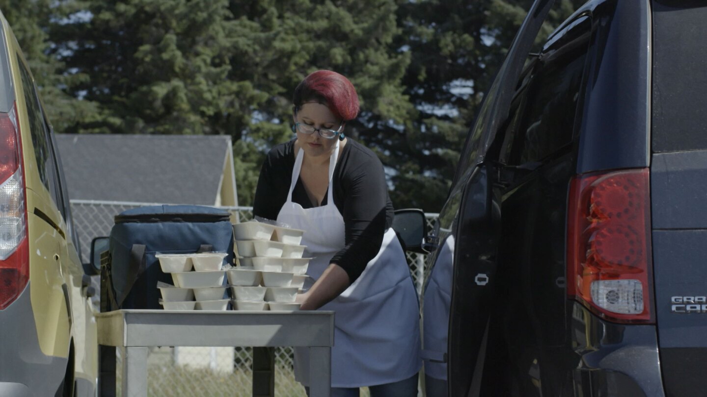 Woman loading meals prepared by United Indian Health Services's food delivery program. | Still from "Tending Nature"
