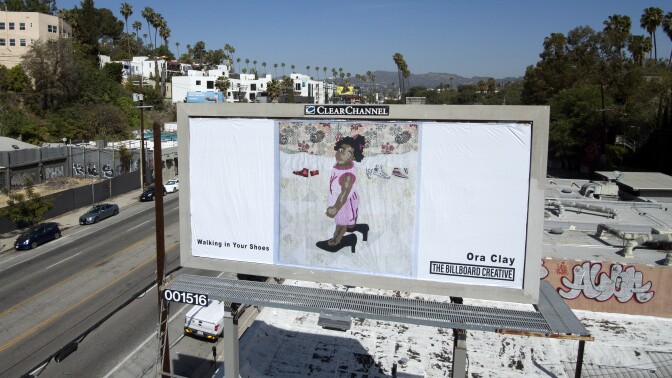 Fiber artist Ora Clay's billboard is located along Sunset Blvd. and shows a young, Black girl in a pink dress wearing a pair of black heels that are too big for her.