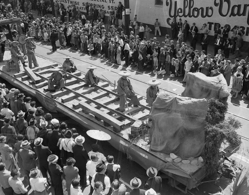 Seven elderly Chinese American men in period costume depict the making of the transcontinental railroad in a parade to celebrate L.A. Union Station's opening.