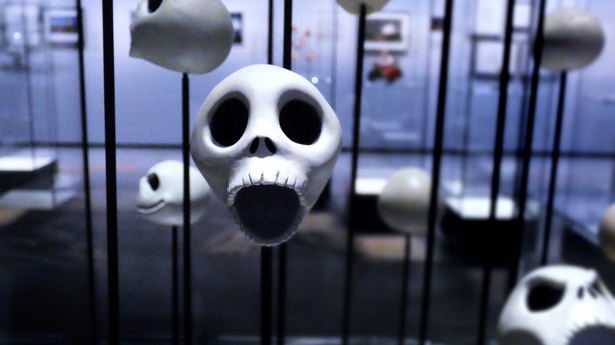 Various Jack Skellington heads are on propped up on black rods in a display at the Academy Museum. The face in the forefront holds a surprised expression.
