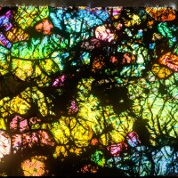A thin, colorful section of a hot desert meteorite found in Africa.