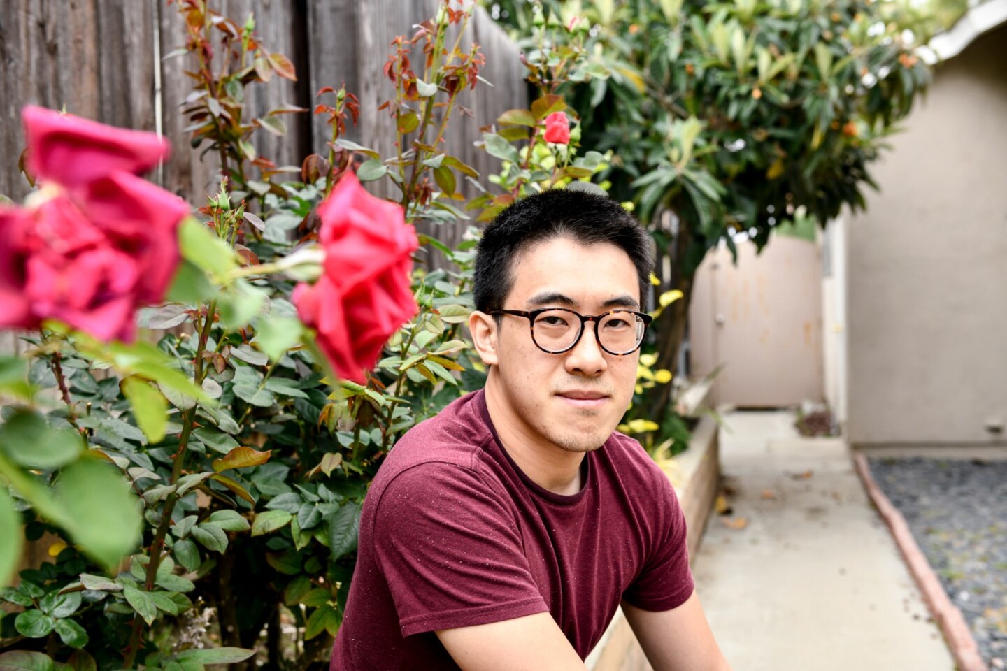 SF State graduate student Richard Lim poses for a portrait at his home in Rowland Heights on May 11, 2021. He wears black glasses, a burgundy shirt and short black hair.