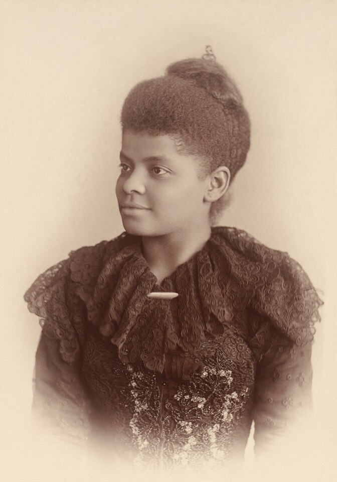 A sepia portrait of Ida B. Wells where she is wearing a piece of clothing with a frilly neckline. Her hair sits atop her head.