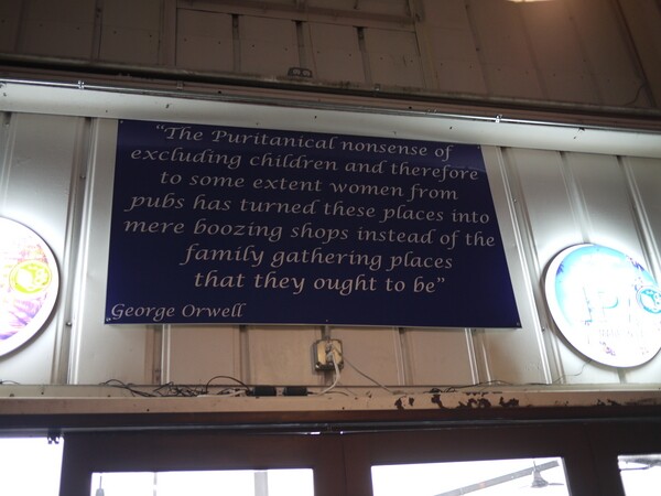 A sign with words from George Orwell that call for the pub as a family gathering place | Photo by George Villanueva