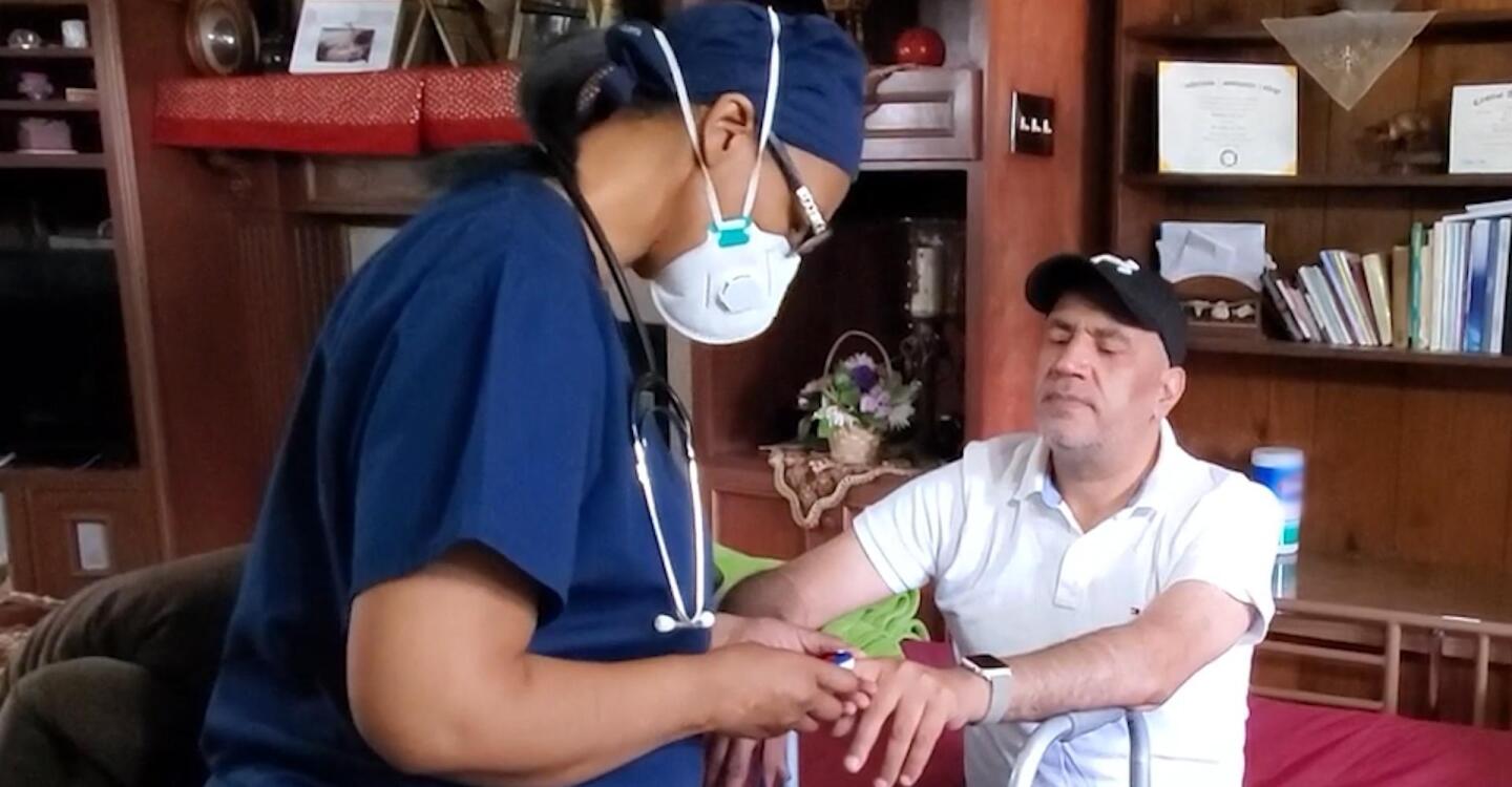 Nurse Rhonda Lee tends to a patient's hand.