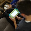 A young boy and young girl using educational tablets.