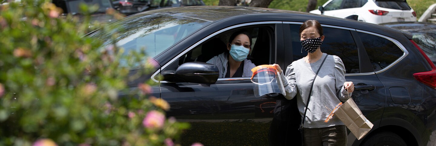 Two nurses pick up face shields made by the 3D PPE Artist Network. | Courtesy of 3D PPE Artist Network