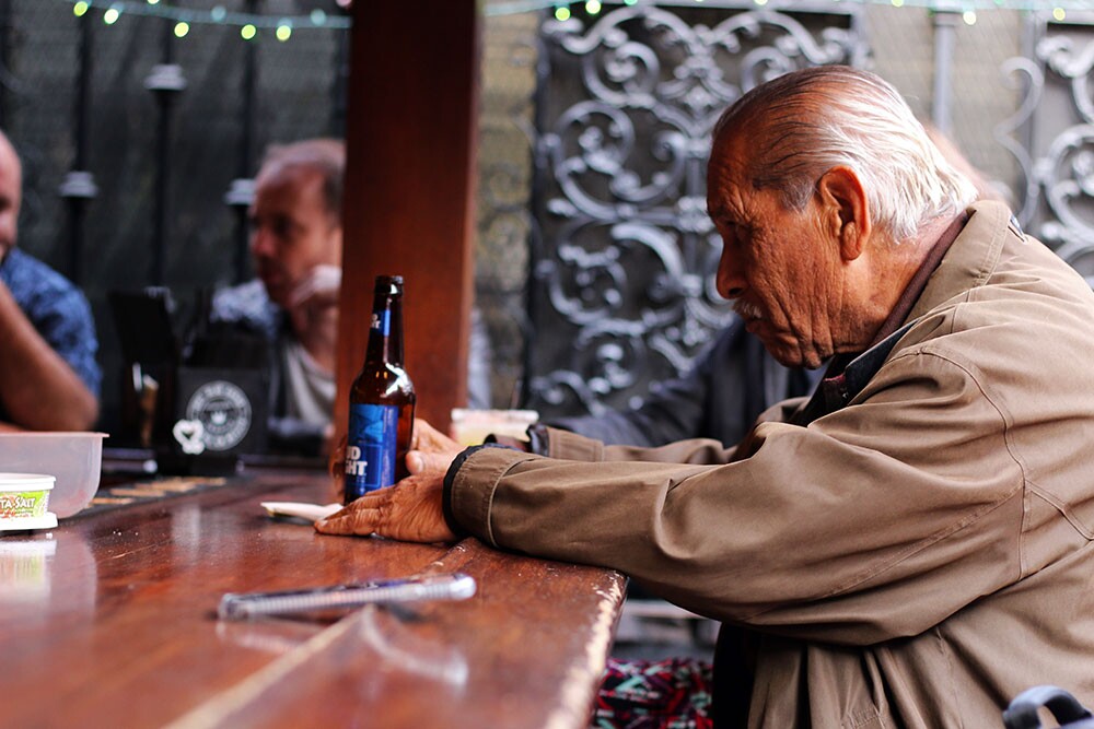 An older man sits at the La Cita bar with a Bud Light.