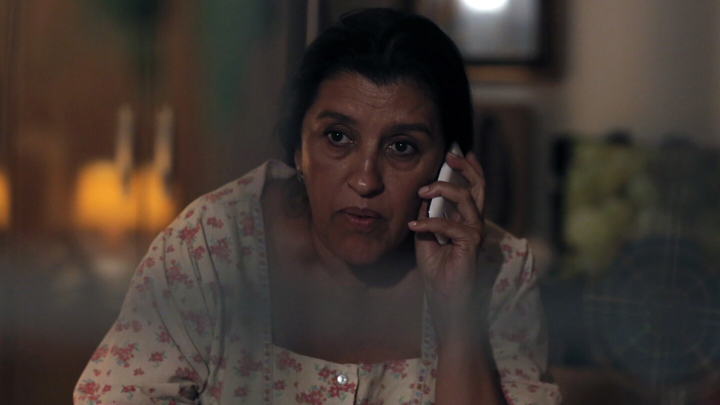 A woman listens intently from her cellphone.