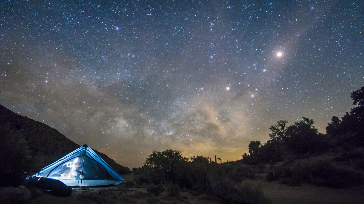 A camping tent under a blanket of night sky on the Pacific Crest Trail.
