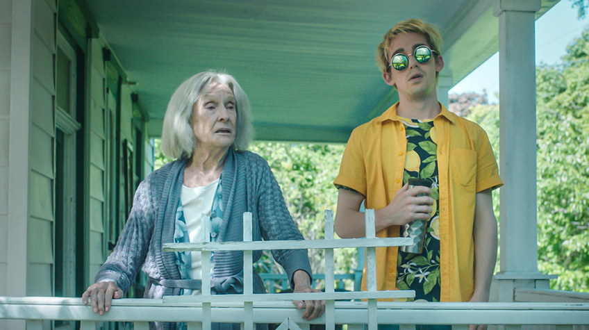 An older woman and a person wearing a yellow polo shirt and sunglasses.