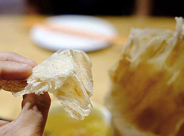 Slightly crispy outside, the layered interior of the roti canai gives way to a satisfying chewiness.