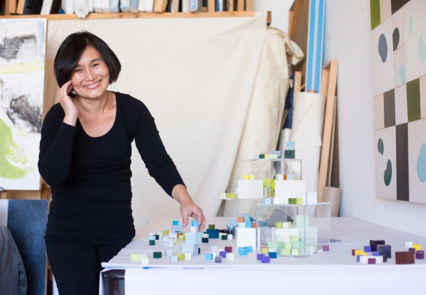 Gina Han arranges the cubes in her installation. | Magali Gauthier Santa Fe Art Colony