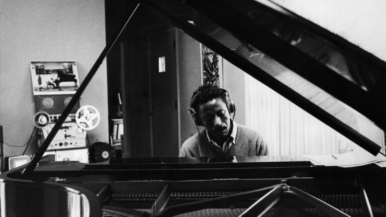 The Sound of Gordon Parks - Closing, a photo of a pianist sitting at the piano with headphones on 