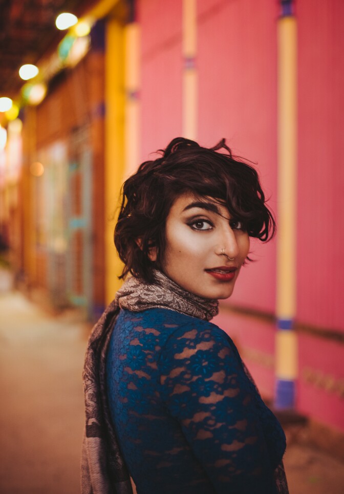 Fatimah Asghar poses around colorful scenery.