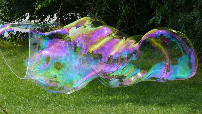 A large bubble being created with a large wand.