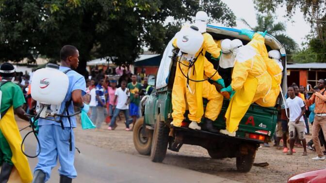 Healthcare workers pile on a truck.