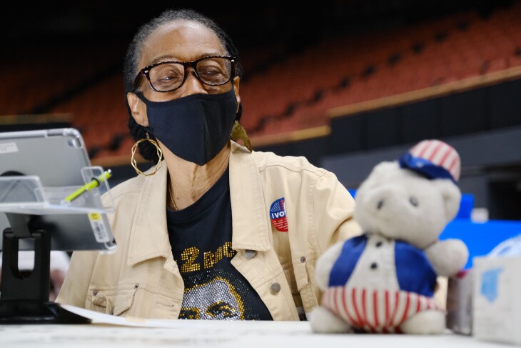 Ernestine Lindsay, poll worker for the last 16 years, brings her own stuffed bear to the vote center at the Forum in Inglewood. | Al Kamalizad for LAist