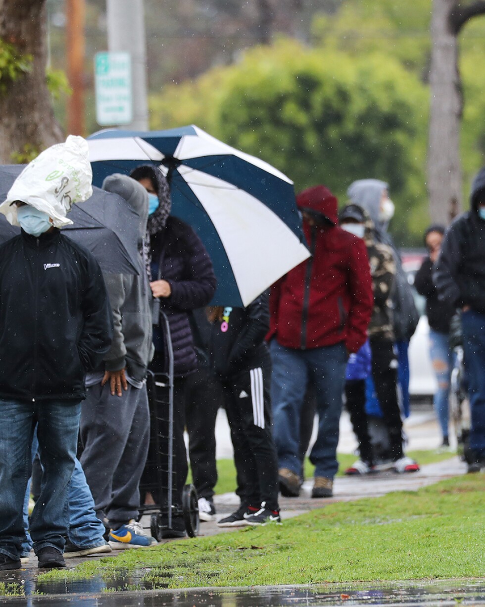 People wait in line to receive food at a Food Bank distribution for those in need as the coronavirus pandemic continues on April 9, 2020 in Van Nuys, California. | Mario Tama/Getty Images