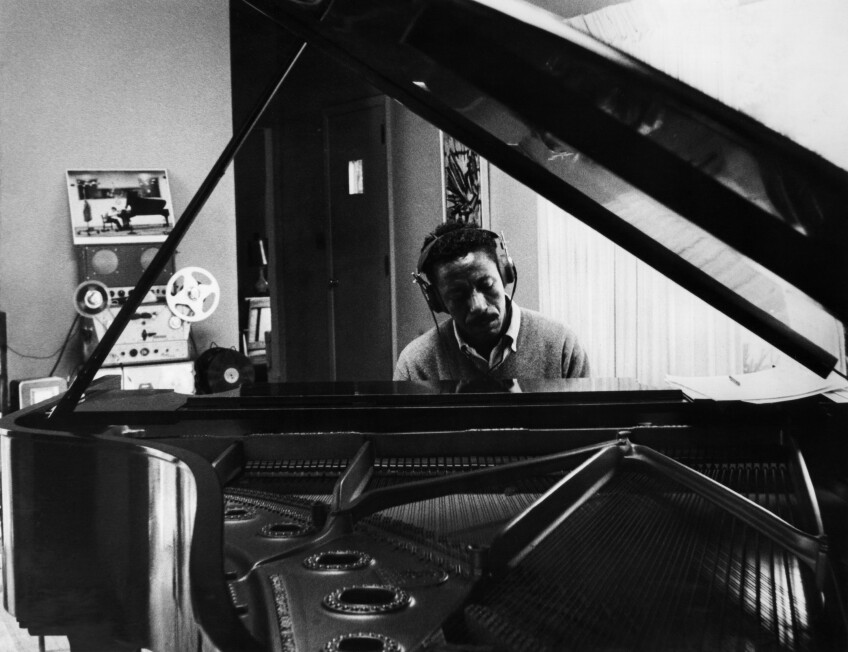 The Sound of Gordon Parks - Closing, a photo of a pianist sitting at the piano with headphones on 