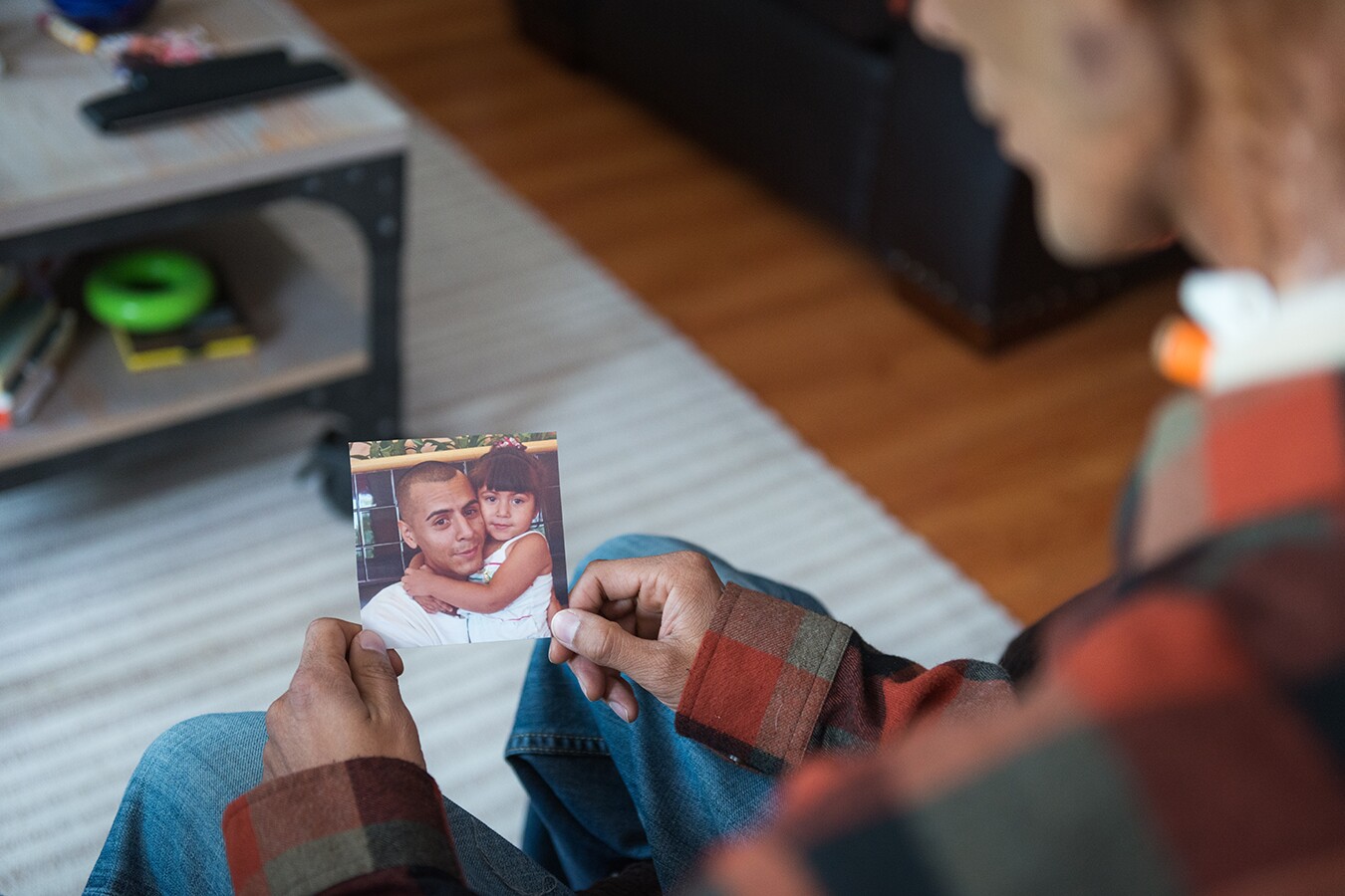 A photograph of Brian looking at a picture of him and Rhianna when she was 3. The photo is shot over his shoulder.