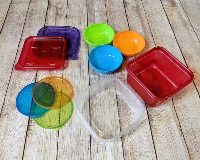 Several round and square containers are laid out on a table.